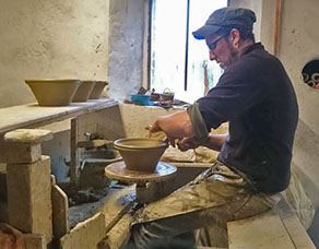 A ceramics worker turning a bowl.